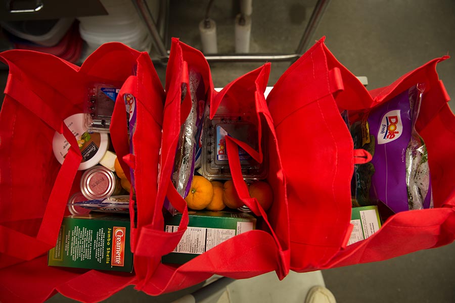 Groceries in red reusable bags.
