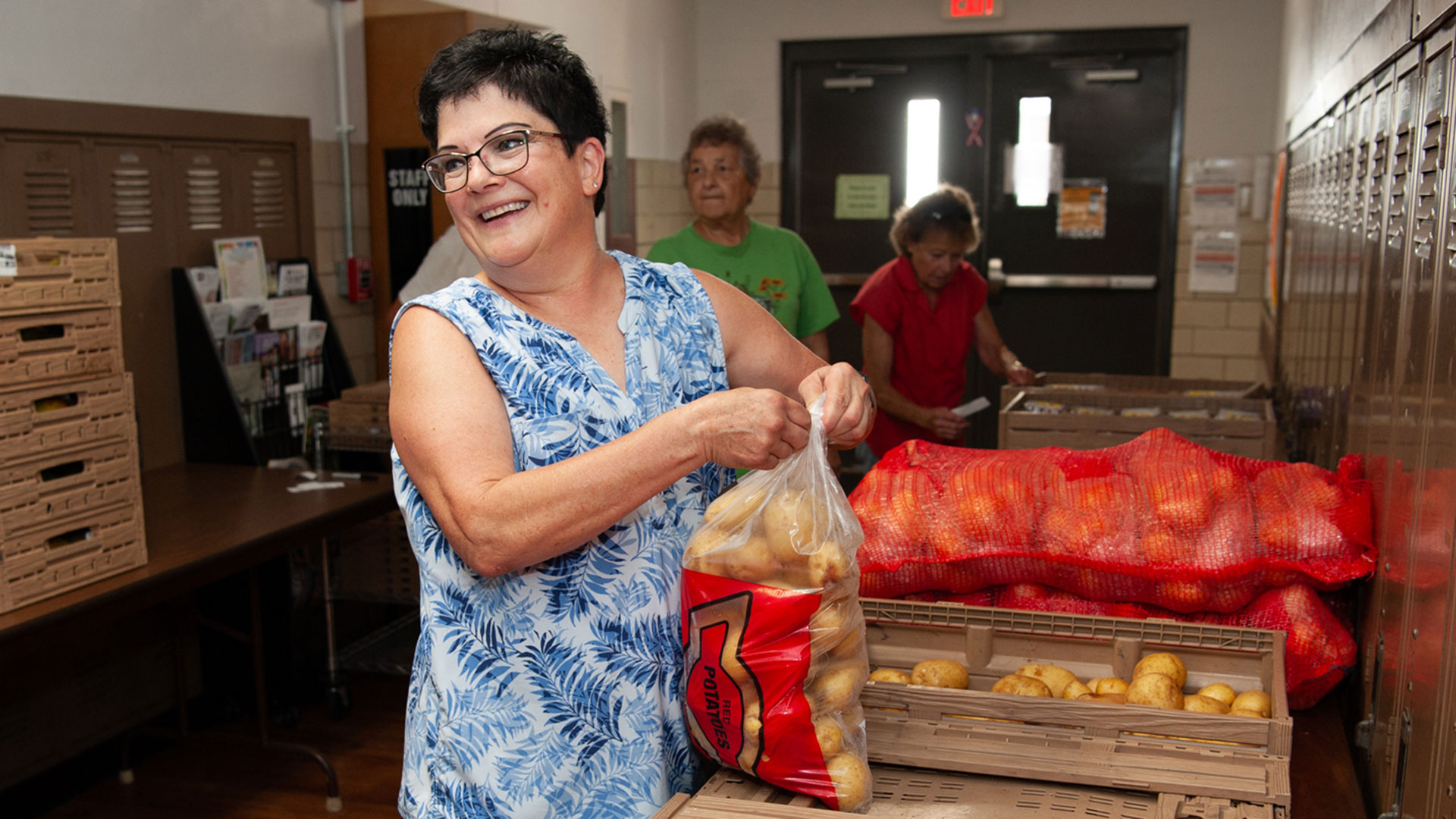 A volunteer opens a bag of potatoes at Helping Hands Food Pantry in Roseville.